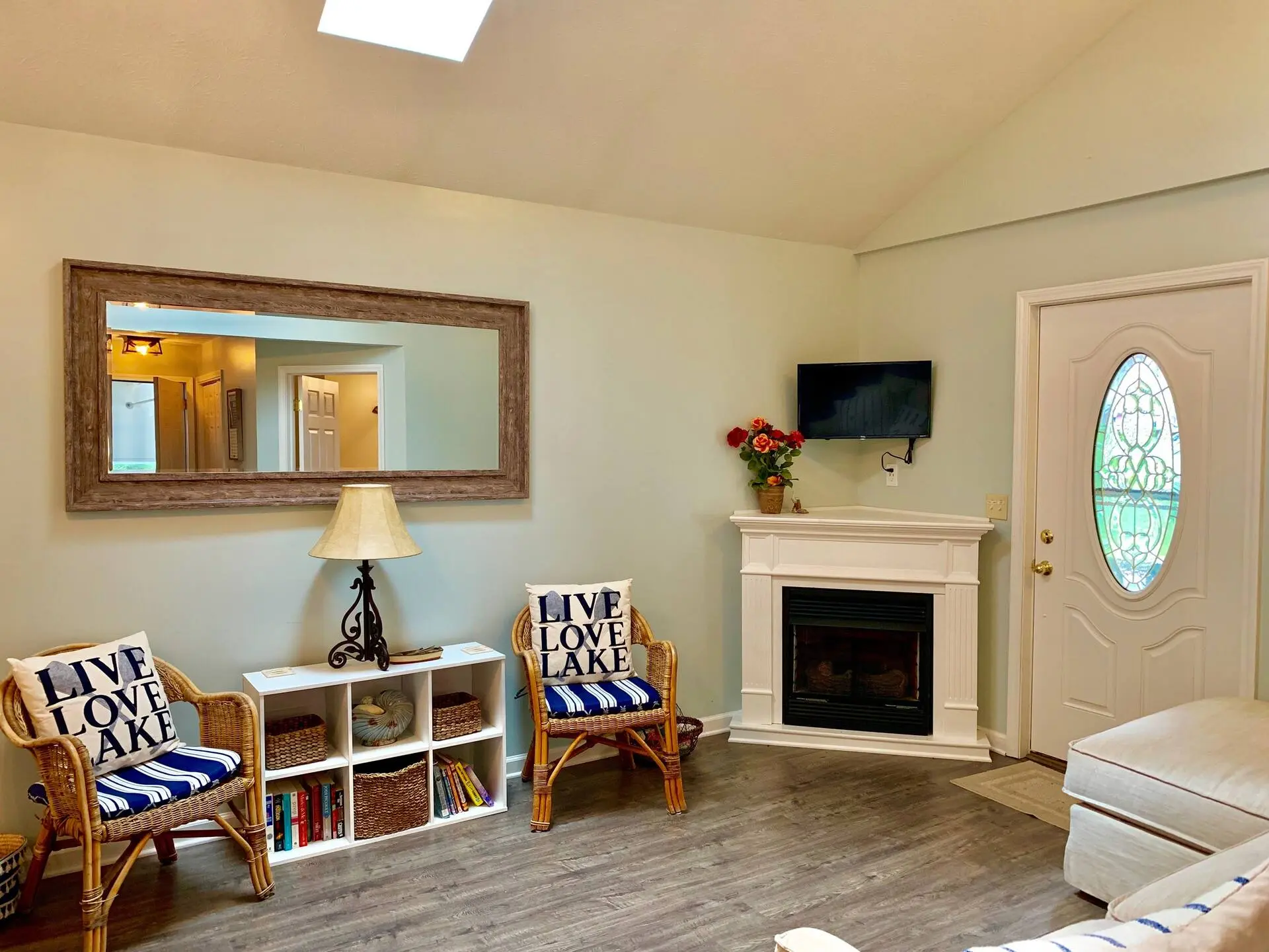 Living room with a fireplace, television, and lake-themed chairs